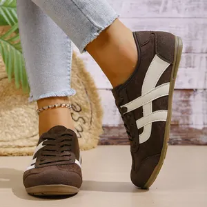 Close-up of retro brown sneakers for women with white tiger stripes and suede texture.