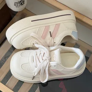 Detailed top view of women's cream platform sneakers with pink stripes and chunky sole
