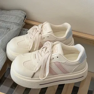 Chic campus style cream platform sneakers with pink and blue accents in detail view