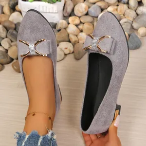 Close-up detail of grey pointed-toe shoes with a luxurious rhinestone bow accent