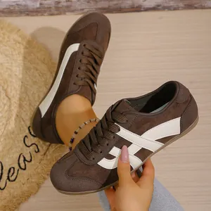 Close-up of women's comfortable brown retro German army trainers with white stripes
