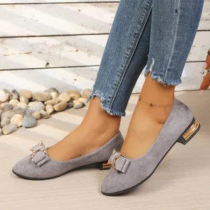 Close-up of grey pointed-toe shoes featuring elegant rhinestone bow and low heels