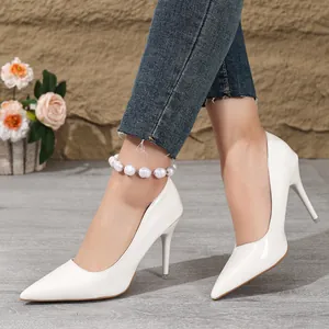 Close-up of elegant white pointed-toe stiletto high heels worn with stylish denim jeans