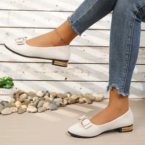 White pointed-toe low-heel shoes with elegant rhinestone bow decoration detail