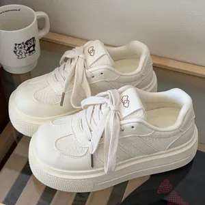 Detail view of cream white chunky platform sneakers with cloud logo on tongue.