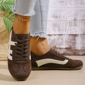 Detailed shot of women's retro brown suede German Army Trainers worn with jeans.