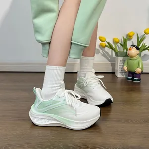 Detailed side view of stylish mint green breathable women's running shoes on a model