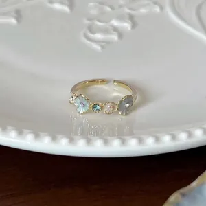Detailed view of a delicate pastel floral adjustable open ring with sparkling crystal accents.
