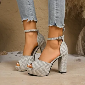 Dettaglio dei sandali platform con tacco largo, motivo geometrico grigio e cinturino.