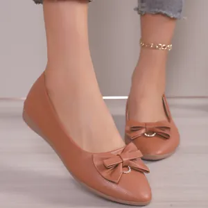 Close-up of brown pointed-toe ballet flats with decorative bow and rhinestone detail