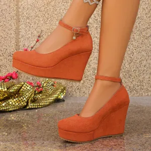 Orange suede wedge high heels with ankle straps and platform sole shown on a model.