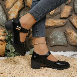 Elegant black chunky heel Mary Jane shoes shown from the side in an outdoor setting.
