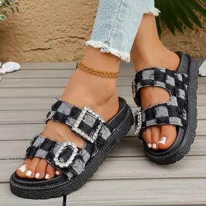 Close-up of black and white checkered denim platform sandals with rhinestone buckles