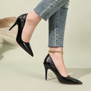 Detailed view of elegant black patent leather pointed-toe stiletto pumps on model