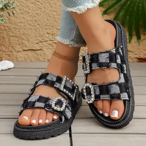 Detail view of checkered denim slippers with sparkling rhinestone buckles
