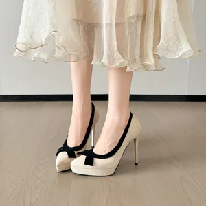 Elegante beige naaldhakken met zwarte strikaccenten en een platformzool ontwerp