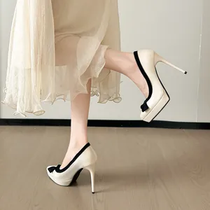 Elegante crèmekleurige pumps met strik, zwarte bies en stevige plateauzool detail