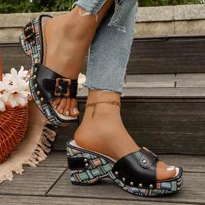Detailopname van modieuze vintage wedge platform slippers met decoratieve gesp en studs