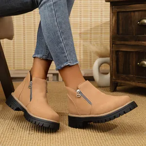 Detailed view of camel suede ankle boots featuring a side zipper and durable lug sole