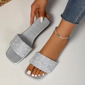 Detail of silver slide sandals with faux pearls and sparkling rhinestones