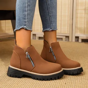 Women's brown side-zipper ankle boots with thick lug soles shown on feet