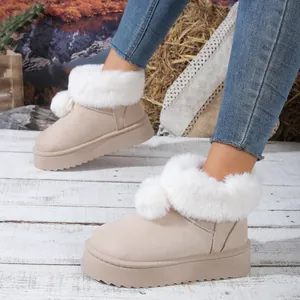 Vista de detalle de botas de nieve beige con plataforma y piel sintética blanca.