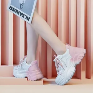 Detailed side view of white and pink gradient chunky sneakers worn by a model