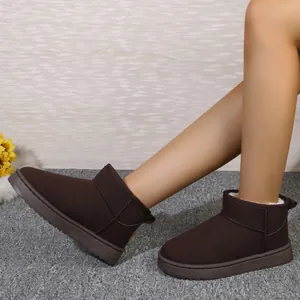 Primer plano de cómodas botas de nieve de ante marrón oscuro con suelas gruesas y forro de piel.