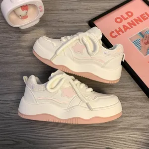 Detailed view of women's white platform sneakers featuring pink stars and chunky laces