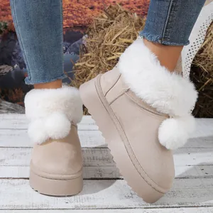 Botas de nieve beige para mujer con piel blanca, pompones y suelas gruesas de invierno.