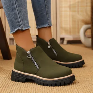 Detailed view of olive green suede ankle boots featuring a side zipper and chunky lug sole