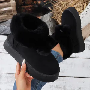 Primer plano de botas de nieve negras de moda con suela gruesa y forro de piel sintética cálido