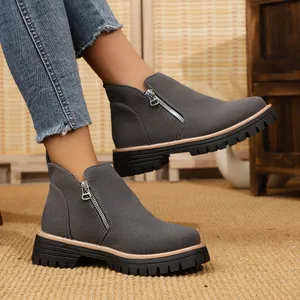 Close-up of grey suede ankle boots featuring a side zipper and durable lug sole