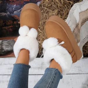 Detalle de botas de nieve marrones para mujer con ribete de piel sintética blanca