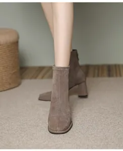 Elegante vista frontale di stivaletti in camoscio taupe con tacco largo da donna.