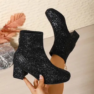 Vista detallada de elegantes botines de tacón alto con purpurina negra para mujer