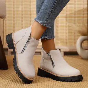 Close-up of women's beige round toe ankle boots with side zipper and thick lug sole