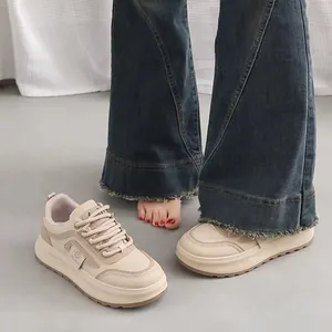 Detail view of beige platform sneakers worn with flared jeans showing sole thickness