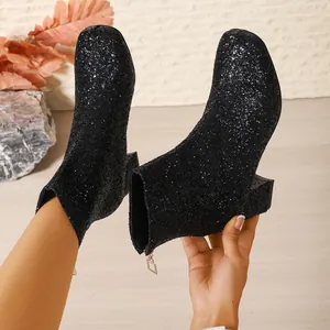 Primer plano de elegantes botines negros de purpurina con acabado brillante y tacón de bloque