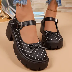 Primer plano de zapatos Mary Jane de lunares negros con suela de plataforma.