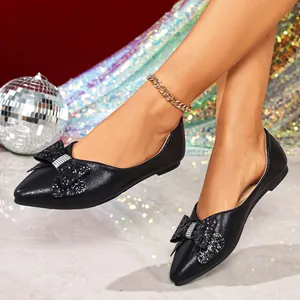 Elegant black pointed-toe flats featuring a sparkling rhinestone bow on the front.
