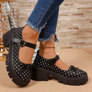 Primer plano de zapatos Mary Jane negros con lunares, suela de plataforma gruesa y lazo