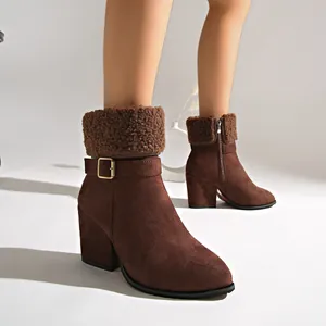 Detailed view of brown suede ankle boots with soft faux fur trim and side buckle strap