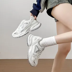 Λεπτομερής προβολή λευκών chunky sneakers με πλέγμα και χοντρές σόλες πλατφόρμας.