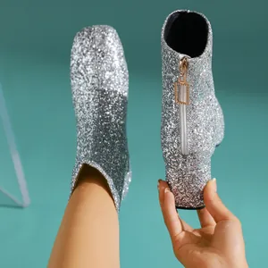 Detalle de la textura de purpurina plateada y la cremallera trasera de estos botines.