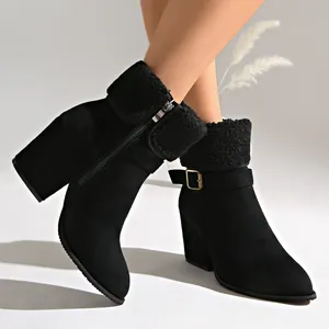 Close-up detail of black suede ankle boots with sherpa cuffs and metal buckle strap.