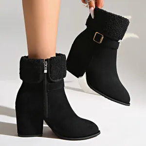 Close-up of women's winter ankle boots with furry cuff, buckle, and chunky heel detail.