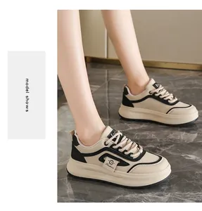 Close-up of beige and black platform sneakers worn by a model on marble floor