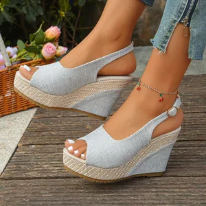 Close-up of women's grey linen peep-toe wedge sandals with woven platform.