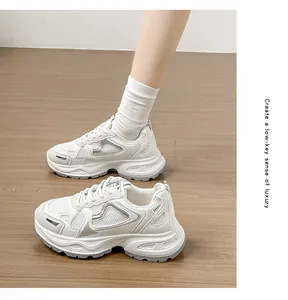Λεπτομέρεια από κομψά λευκά sneakers με πλατφόρμα, παχιά σόλα και κλείσιμο με κορδόνια